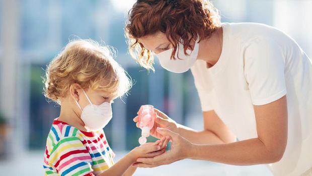 Family with kids in face mask in shopping mall or airport. Mother and child wear facemask during coronavirus and flu outbreak. Virus and illness protection, hand sanitizer in public crowded place.