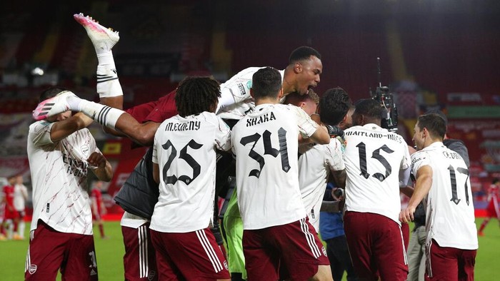 Arsenal players celebrate after winning the English League Cup fourth round soccer match between Liverpool and Arsenal at Anfield, Liverpool, England, Thursday, Oct. 1, 2020. Arsenal defeated Liverpool 5-4 in penalties. (Peter Byrne/Pool via AP)