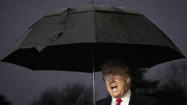 WASHINGTON, DC DECEMBER 10: U.S. President Donald Trump holds an umbrella as he speaks to journalists before boarding Marine One on the South Lawn of the White House on December 10, 2019 in Washington, DC. President Trump is headed to Hershey, Pennsylvania for a campaign rally. Earlier in the day, House Democrats announced they will seek two articles of impeachment against the president.   Drew Angerer/Getty Images/AFP