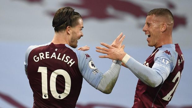 Aston Villa's Jack Grealish, left, celebrates after scoring his side's sixth goal with Aston Villa's Ross Barkley during the English Premier League soccer match between Aston Villa and Liverpool at the Villa Park stadium in Birmingham, England, Sunday, Oct. 4, 2020. (Peter Powell/Pool via AP)