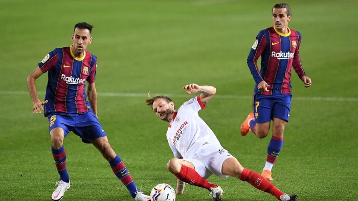 Barcelona vs Sevilla BARCELONA, SPAIN - OCTOBER 04: Sergio Busquets of Barcelona and Antoine Griezmann of Barcelona battles for possession with Ivan Rakitic of Sevilla FC during the La Liga Santander match between FC Barcelona and Sevilla FC at Camp Nou on October 04, 2020 in Barcelona, Spain. Football Stadiums around Europe remain empty due to the Coronavirus Pandemic as Government social distancing laws prohibit fans inside venues resulting in fixtures being played behind closed doors. (Photo by David Ramos/Getty Images)