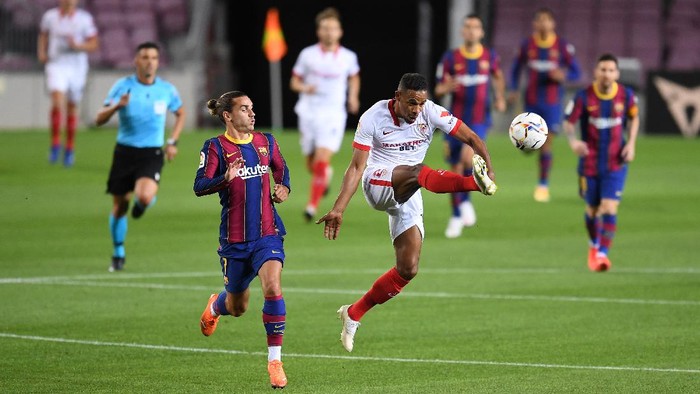 BARCELONA, SPAIN - OCTOBER 04: Antoine Griezmann of Barcelona  battles for possession with  Fernando of Sevilla FC  during the La Liga Santander match between FC Barcelona and Sevilla FC at Camp Nou on October 04, 2020 in Barcelona, Spain. Football Stadiums around Europe remain empty due to the Coronavirus Pandemic as Government social distancing laws prohibit fans inside venues resulting in fixtures being played behind closed doors. (Photo by David Ramos/Getty Images)