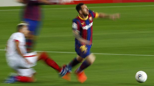 Barcelona's Lionel Messi is tackled by Sevilla's Joan Jordan during the Spanish La Liga soccer match between FC Barcelona and Sevilla FC at the Camp Nou stadium in Barcelona, Spain, Sunday, Oct. 4, 2020. (AP Photo/Joan Monfort)