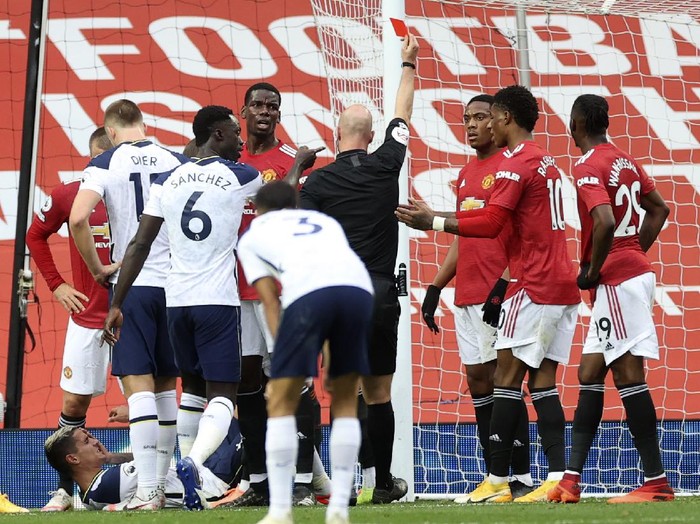Referee Anthony Taylor shows a red card to Manchester Uniteds Anthony Martial, 3rd right, during the English Premier League soccer match between Manchester United and Tottenham Hotspur at Old Trafford in Manchester, England, Sunday, Oct. 4, 2020. (Carl Recine/Pool via AP)