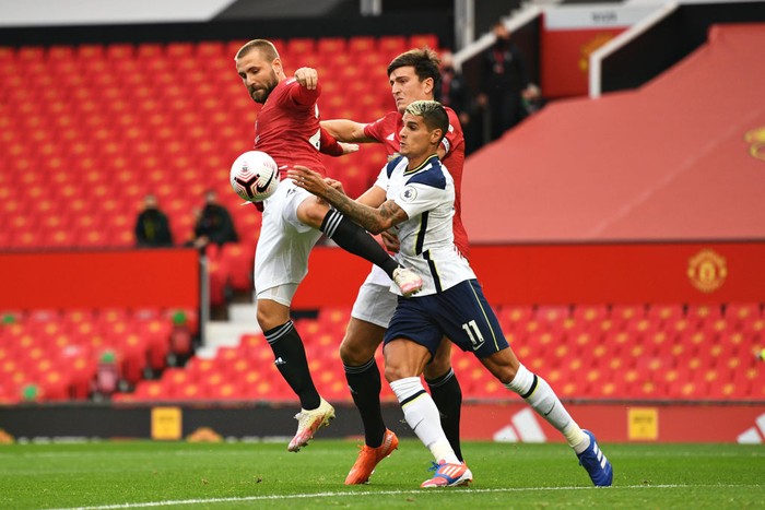 MANCHESTER, ENGLAND - OCTOBER 04: Erik Lamela of Tottenham Hotspur battles for possession with Luke Shaw and Harry Maguire of Manchester United during the Premier League match between Manchester United and Tottenham Hotspur at Old Trafford on October 04, 2020 in Manchester, England. Sporting stadiums around the UK remain under strict restrictions due to the Coronavirus Pandemic as Government social distancing laws prohibit fans inside venues resulting in games being played behind closed doors. (Photo by Oli Scarff - Pool/Getty Images)