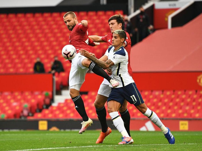 MANCHESTER, ENGLAND - OCTOBER 04: Erik Lamela of Tottenham Hotspur battles for possession with Luke Shaw and Harry Maguire of Manchester United during the Premier League match between Manchester United and Tottenham Hotspur at Old Trafford on October 04, 2020 in Manchester, England. Sporting stadiums around the UK remain under strict restrictions due to the Coronavirus Pandemic as Government social distancing laws prohibit fans inside venues resulting in games being played behind closed doors. (Photo by Oli Scarff - Pool/Getty Images)
