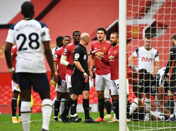 MANCHESTER, ENGLAND - OCTOBER 04: Players of Manchester United confront Referee Anthony Taylor as he shows a red card to Anthony Martial of Manchester United during the Premier League match between Manchester United and Tottenham Hotspur at Old Trafford on October 04, 2020 in Manchester, England. Sporting stadiums around the UK remain under strict restrictions due to the Coronavirus Pandemic as Government social distancing laws prohibit fans inside venues resulting in games being played behind closed doors. (Photo by Oli Scarff - Pool/Getty Images)