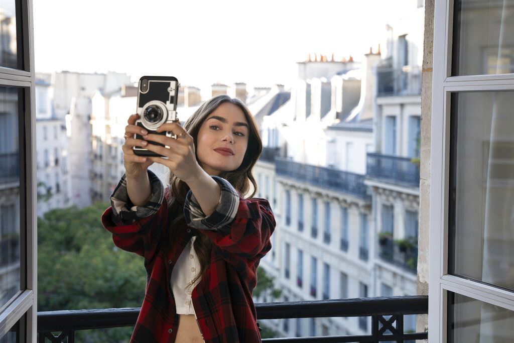 This image released by Netflix shows William Abadie, left, and Lily Collins in a scene from the series 