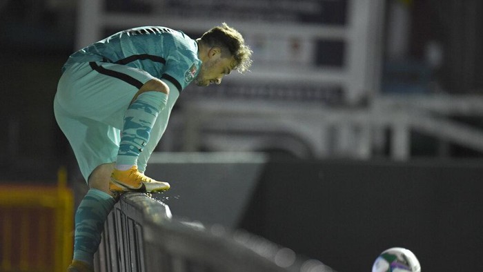 Liverpools Xherdan Shaqiri climbs over the hoarding to get the ball during the English League Cup third round soccer match between Lincoln City and Liverpool at the LNER stadium, Lincoln, England, Thursday, Sept. 24, 2020. (Peter Powell, Pool via AP)