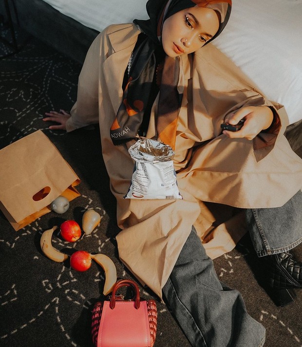 difoto tersebut Ia hanya duduk di bawah sambil bersandar pada kasurnya dan ditambah dengan properti makanannya.