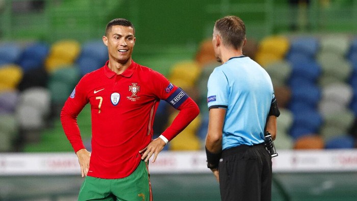 Portugals Cristiano Ronaldo, left, speaks with referee Paolo Valeri during the international friendly soccer match between Portugal and Spain at the Jose Alvalade stadium in Lisbon, Wednesday, Oct. 7, 2020. (AP Photo/Armando Franca)