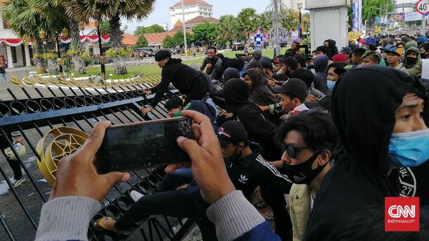 Situasi Aksi Tolak Omnibus Law Cipta Kerja di Surabaya memanas. Massa mahasiswa dan masyarakat mulai menjebol kawat berduri dan pagar Gedung Negara Grahadi, Surabaya.