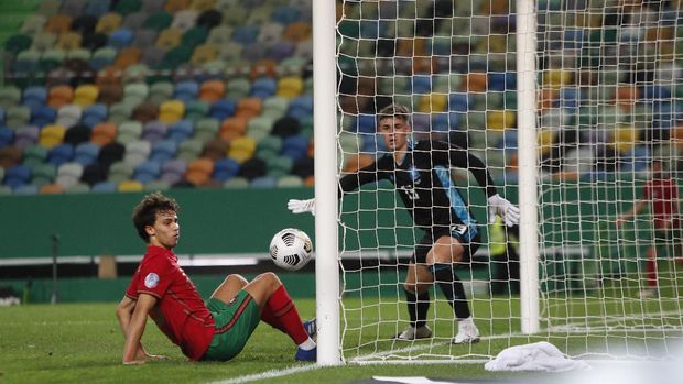 Portugal's Joao Felix, left, and Spain goalkeeper Kepa watch as the ball runs past the goal during the international friendly soccer match between Portugal and Spain at the Jose Alvalade stadium in Lisbon, Wednesday, Oct. 7, 2020. (AP Photo/Armando Franca)