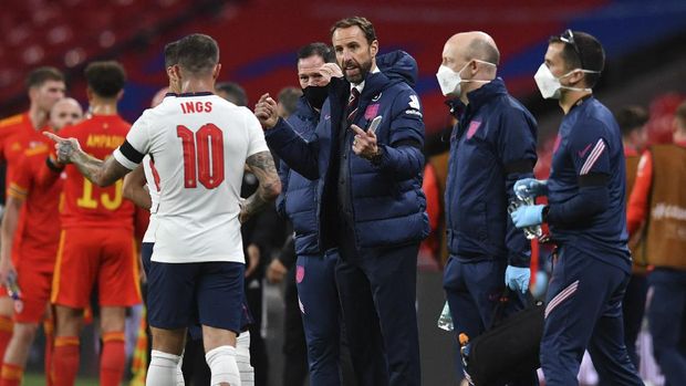 England's coach Gareth Southgate, center talks to his player Danny Ings during the international friendly soccer match between England and Wales at Wembley stadium in London, Thursday Oct. 8, 2020. (Glynn Kirk/Pool via AP)