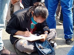 Viral, Mahasiswa Ini Sibuk Kerjakan Tugas Sambil Ikut Demo Omnibus Law