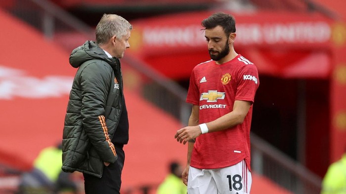 Manchester Uniteds Bruno Fernandes talks with Manchester Uniteds manager Ole Gunnar Solskjaer, center, as Tottenhams manager Jose Mourinho walks by during the English Premier League soccer match between Manchester United and Tottenham Hotspur at Old Trafford in Manchester, England, Sunday, Oct. 4, 2020. (Carl Recine/Pool via AP)