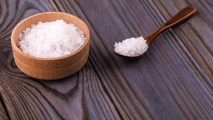 Garam Epsom White bath salt in a wooden bowl with a spoon on a wooden table