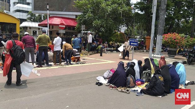 Massa aksi unjuk rasa 1310 tolak Omnibhs Law Cipta Kerja melaksanakan Salat Zuhur di trotoar depan Gedung Sapta Pesona Kementerian Pariwisata dan Ekonomi Kreatif, Selasa (13/10)