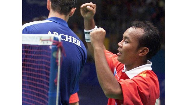 Indonesia's Tri Kusharyanto raises his arms in victory after he and partner Minarti Timur defeated Great Britain's Simon Archer and Joanne Goode 2-15, 17-15, 15-11 in the semifinal of the mixed doubles badminton at the Sydney Olympic Park 20 September 2000. The Indonesians will meet China's Zhang Jun and Gao Ling in the final. AFP PHOTO/Robyn BECK (Photo by ROBYN BECK / AFP)