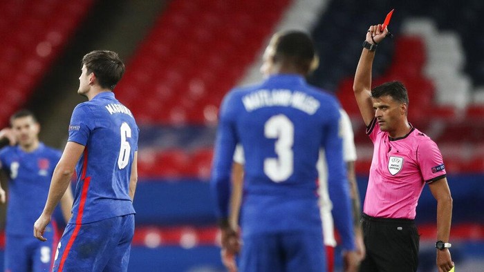 Referee Jesus Gil Manzano, right, shows a red card to Englands Harry Maguire, left, during the UEFA Nations League soccer match between England and Denmark at Wembley Stadium in London, England, Wednesday, Oct. 14, 2020. (Nick Potts/Pool via AP)