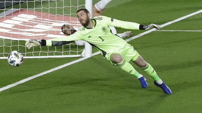 Switzerlands Loris Benito, second right watches as Spain goalkeeper David De Gea saves his shot on goal during the UEFA Nations League soccer match between Spain and Switzerland in Madrid, Spain, Saturday, Oct. 10, 2020. (AP Photo/Manu Fernandez)