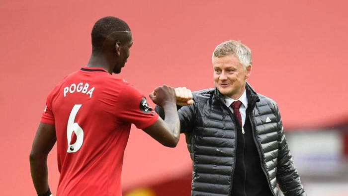 Paul Pogba and Ole Gunnar Solskjaer MANCHESTER, ENGLAND - JULY 04: Paul Pogba of Manchester United and Ole Gunnar Solskjaer, Manager of Manchester United fist bump following during the Premier League match between Manchester United and AFC Bournemouth at Old Trafford on July 04, 2020 in Manchester, England. Football Stadiums around Europe remain empty due to the Coronavirus Pandemic as Government social distancing laws prohibit fans inside venues resulting in all fixtures being played behind closed doors. (Photo by Peter Powell/Pool via Getty Images)