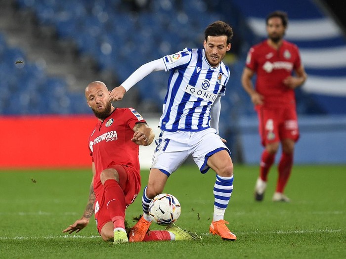 SAN SEBASTIAN, SPAIN - OCTOBER 03: David Silva of Real Sociedad is challenged by David Timor of Getafe CF during the La Liga Santader match between Real Sociedad and Getafe CF at Estadio Anoeta on October 03, 2020 in San Sebastian, Spain. Football Stadiums around Europe remain empty due to the Coronavirus Pandemic as Government social distancing laws prohibit fans inside venues resulting in fixtures being played behind closed doors. (Photo by Juan Manuel Serrano Arce/Getty Images)