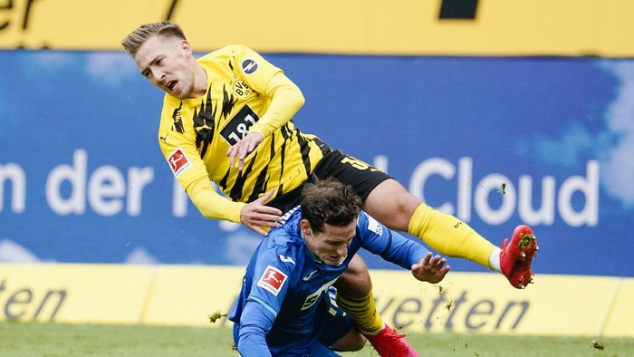 Hoffenheims Sebastian Rudy, bottom, and Dortmunds Felix Passlack challenge for the ball during the German soccer Bundesliga match between TSG Hoffenheim and Borussia Dortmund in Sinsheim, Germany, Saturday, Oct. 17, 2020. (Uwe Anspach/dpa via AP)