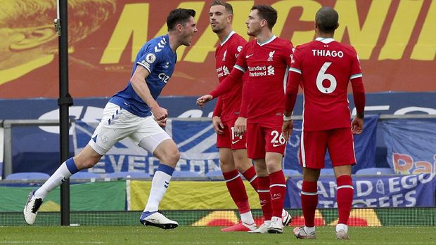 Everton's Michael Keane, left, celebrates scoring his side's first goal as Liverpool's Jordan Henderson, second left, reacts during the English Premier League soccer match between Everton and Liverpool at Goodison Park stadium, in Liverpool, England, Saturday, Oct. 17, 2020. (Peter Byrne/Pool via AP)