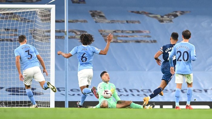 MANCHESTER, ENGLAND - OCTOBER 17: Pierre-Emerick Aubameyang of Arsenal has his shot saved by Ederson of Manchester City during the Premier League match between Manchester City and Arsenal at Etihad Stadium on October 17, 2020 in Manchester, England. Sporting stadiums around the UK remain under strict restrictions due to the Coronavirus Pandemic as Government social distancing laws prohibit fans inside venues resulting in games being played behind closed doors. (Photo by Michael Regan/Getty Images)