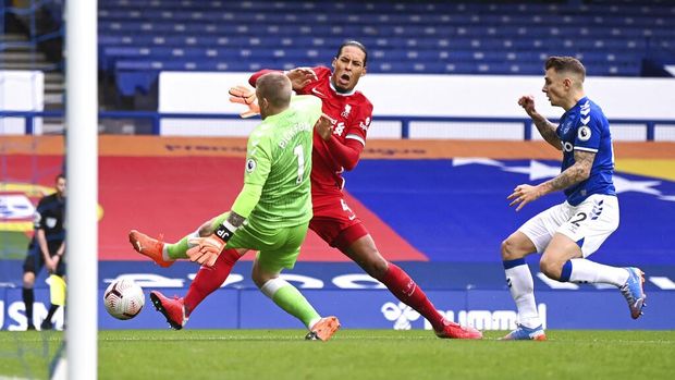 Liverpool's Virgil van Dijk, centre, is tackled and injured by Everton's goalkeeper Jordan Pickford, left, causing him to leave the match injured during the English Premier League soccer match between Everton and Liverpool at Goodison Park stadium, in Liverpool, England, Saturday, Oct. 17, 2020. (Laurence Griffiths/Pool via AP)