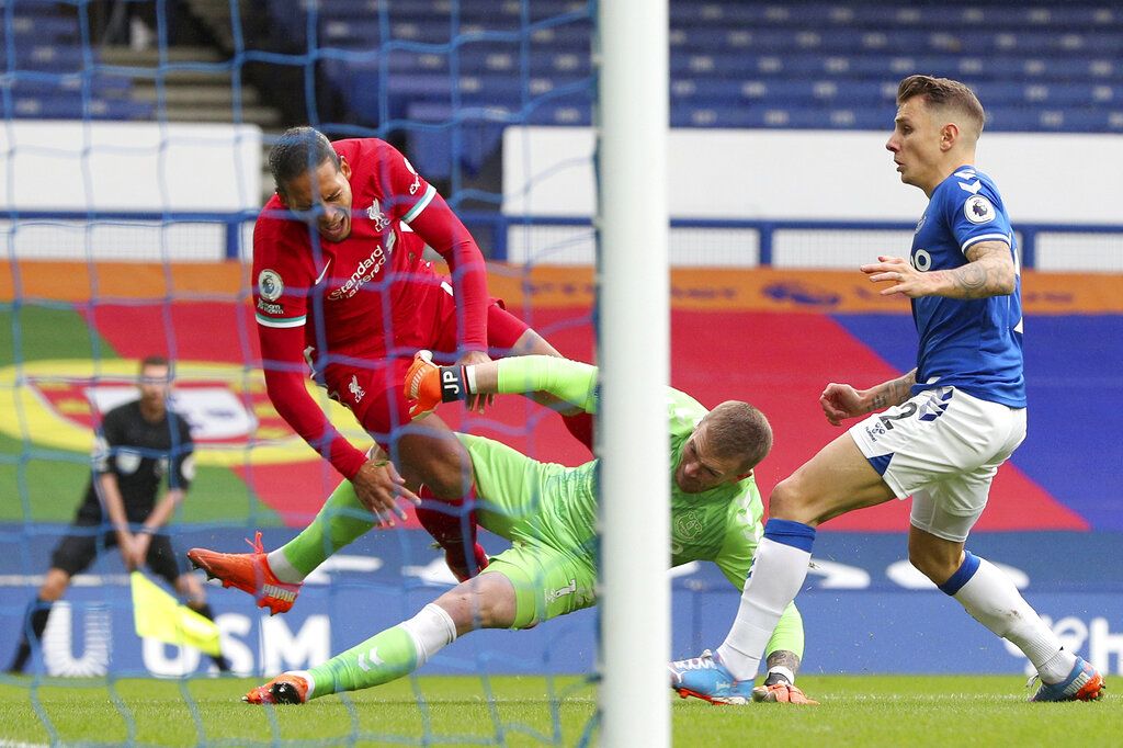 Liverpool's Virgil van Dijk, top left, is tackled by Everton goalkeeper Jordan Pickford, center, before leaving the match injured during the English Premier League soccer match between Everton and Liverpool at the Goodison Park Stadium, in Liverpool, England, on Saturday, October 17.  2020. (Peter Byrne / Pool via AP)