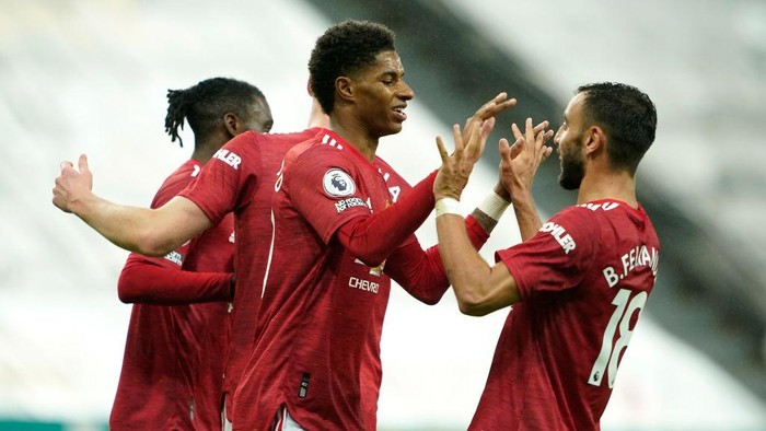 NEWCASTLE UPON TYNE, ENGLAND - OCTOBER 17: Marcus Rashford of Manchester United celebrates with Bruno Fernandes after scoring his teams fourth goal during the Premier League match between Newcastle United and Manchester United at St. James Park on October 17, 2020 in Newcastle upon Tyne, England. Sporting stadiums around the UK remain under strict restrictions due to the Coronavirus Pandemic as Government social distancing laws prohibit fans inside venues resulting in games being played behind closed doors. (Photo by Owen Humphreys - Pool/Getty Images)
