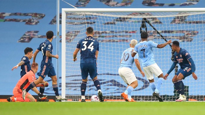 MANCHESTER, ENGLAND - OCTOBER 17: Raheem Sterling of Manchester City scores his sides first goal during the Premier League match between Manchester City and Arsenal at Etihad Stadium on October 17, 2020 in Manchester, England. Sporting stadiums around the UK remain under strict restrictions due to the Coronavirus Pandemic as Government social distancing laws prohibit fans inside venues resulting in games being played behind closed doors. (Photo by Alex Livesey/Getty Images)
