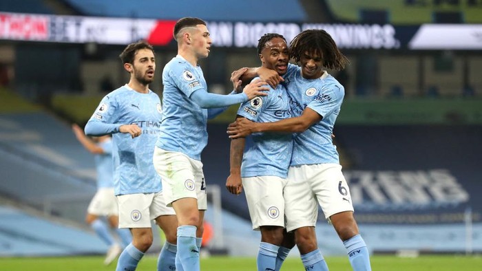 MANCHESTER, ENGLAND - OCTOBER 17: Raheem Sterling of Manchester City celebrates with teammates after scoring his teams first goal during the Premier League match between Manchester City and Arsenal at Etihad Stadium on October 17, 2020 in Manchester, England. Sporting stadiums around the UK remain under strict restrictions due to the Coronavirus Pandemic as Government social distancing laws prohibit fans inside venues resulting in games being played behind closed doors. (Photo by Martin Rickett - Pool/Getty Images)