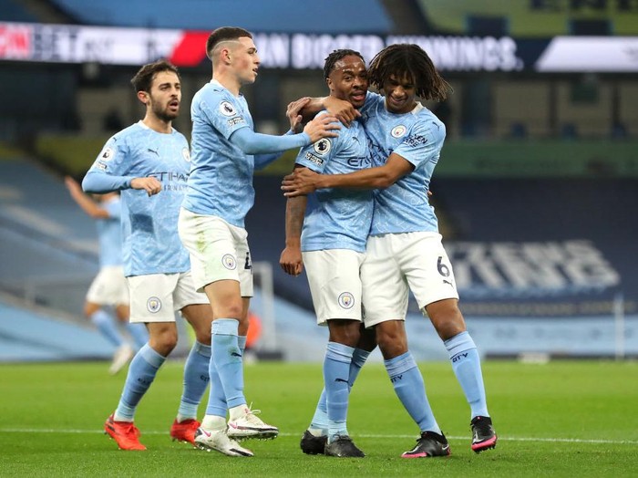 MANCHESTER, ENGLAND - OCTOBER 17: Raheem Sterling of Manchester City celebrates with teammates after scoring his teams first goal during the Premier League match between Manchester City and Arsenal at Etihad Stadium on October 17, 2020 in Manchester, England. Sporting stadiums around the UK remain under strict restrictions due to the Coronavirus Pandemic as Government social distancing laws prohibit fans inside venues resulting in games being played behind closed doors. (Photo by Martin Rickett - Pool/Getty Images)