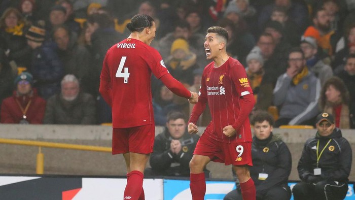 WOLVERHAMPTON, ENGLAND - JANUARY 23:  Roberto Firmino of Liverpool celebrates with team-mate Virgil van Dijk after scoring their second goal during the Premier League match between Wolverhampton Wanderers and Liverpool FC at Molineux on January 23, 2020 in Wolverhampton, United Kingdom. (Photo by Catherine Ivill/Getty Images)