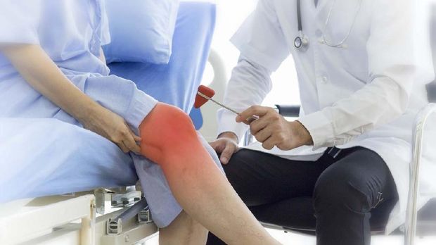 Health care concept; Old patient suffering from knee pain at the hospital. Doctor testing patella reflex or knee-jerk reflex with red hummer jerk on her knee.