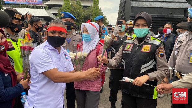 Massa buruh demo tola uu cipta kerja di Semarang bagikan bunga ke Polisi.