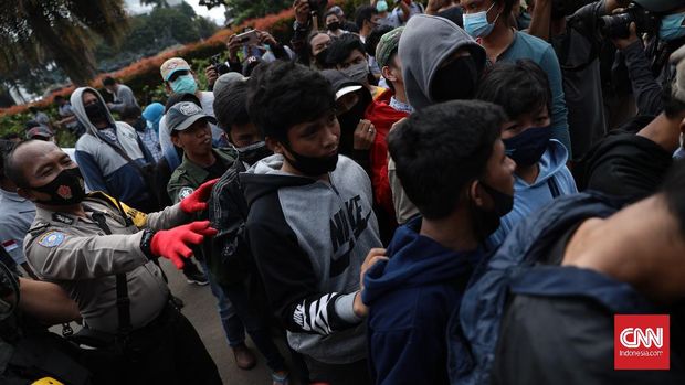 Petugas kepolisian mengamankan sejumlah massa di kawasan Patung Kuda, Jakarta, Selasa, 20 Oktober 2020. CNN Indonesia/ Bisma Septalisma