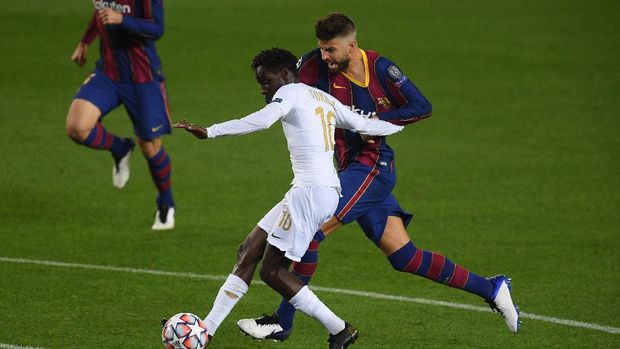 BARCELONA, SPAIN - OCTOBER 20: Tokmac Nguen of Ferencvaros Budapest receives a foul from FC Barcelona's Gerard Piqué that leads to a penalty during the UEFA Champions League Group G stage match between FC Barcelona and the Ferencvaros Budapest at the Camp Nou on October 20, 2020 in Barcelona.  Spain.  Sports stadiums across Europe remain under strict restrictions due to the coronavirus pandemic, as government social distancing laws prohibit fans from entering venues, causing matches to be played behind closed doors.  (Photo by Alex Caparros / Getty Images)