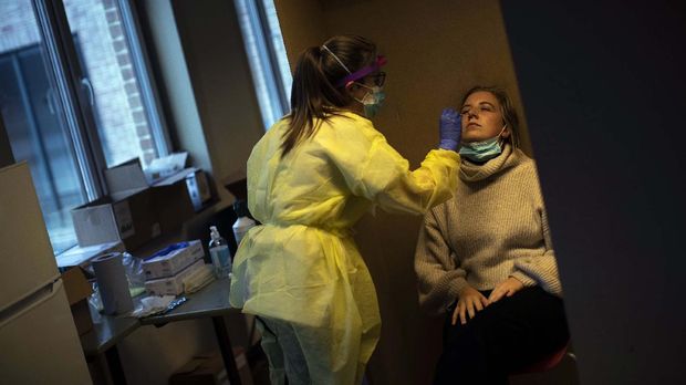 A medical worker, wearing full protective gear, takes a nose swab from a patient to be tested for COVID-19 in a Red Cross test centre in Brussels, Tuesday, Oct. 13, 2020. Authorities in Belgium, one of the European countries hit hardest by the coronavirus, are warning that the number of cases is rising at a 