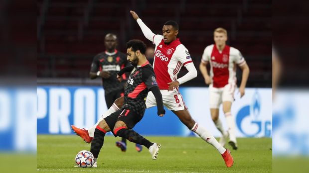 Liverpool's Mohamed Salah, left, controls the ball in front of Ajax's Ryan Gravenberch, during the group D Champions League soccer match between Ajax and Liverpool at the Johan Cruyff ArenA in Amsterdam, Netherlands, Wednesday, Oct. 21, 2020. (AP Photo/Peter Dejong)