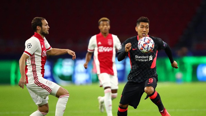 AMSTERDAM, NETHERLANDS - OCTOBER 21: Roberto Firminho of Liverpool runs with the ball under pressure from Daley Blind of Ajax during the UEFA Champions League Group D stage match between Ajax Amsterdam and Liverpool FC at Johan Cruijff Arena on October 21, 2020 in Amsterdam, Netherlands. (Photo by Dean Mouhtaropoulos/Getty Images)