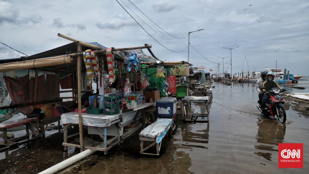 Warga beraktivitas saat banjir rob di Pelabuhan Kali Adem, Muara Angke, Jakarta, Kamis, 22 Oktober 2020. Banjir yang terjadi sejak Senin (19/10) itu dikarenakan pasang surut air laut. CNN Indonesia/Bisma Septalisma