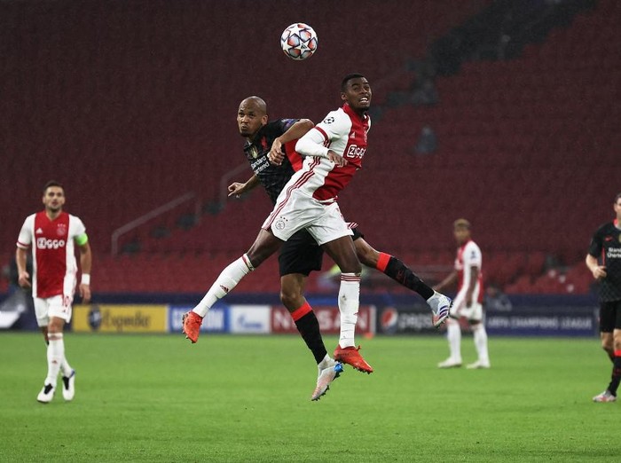 Liverpools Brazilian midfielder Fabinho (L) jumps for the ball with Ajaxs Dutch midfielder Ryan Gravenberch  during the UEFA Champions League Group D first-leg football match between Ajax Amsterdam and Liverpool FC at the Johan Cruijff Arena in Amsterdam on October 21, 2020. (Photo by KENZO TRIBOUILLARD / AFP)