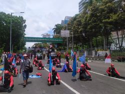Gaya Massa Buruh Duduk Berjarak di Jalan Sisi Monas Usai Long March