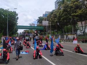 Gaya Massa Buruh Duduk Berjarak di Jalan Sisi Monas Usai Long March Gaya Massa Buruh Duduk Berjarak di Jalan Sisi Monas Usai Long March