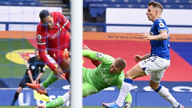 LIVERPOOL, ENGLAND - OCTOBER 17: Virgil van Dijk of Liverpool is tackled by Jordan Pickford of Everton which led to Virgil van Dijk being substituted for an injury during the Premier League match between Everton and Liverpool at Goodison Park on October 17, 2020 in Liverpool, England. Sporting stadiums around the UK remain under strict restrictions due to the Coronavirus Pandemic as Government social distancing laws prohibit fans inside venues resulting in games being played behind closed doors. (Photo by Laurence Griffiths/Getty Images)