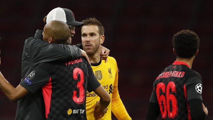 Liverpools manager Jurgen Klopp, left, embraces his players Fabinho, left and goalkeeper Adrian, center as they celebrate their victory following the group D Champions League soccer match between Ajax and Liverpool at the Johan Cruyff ArenA in Amsterdam, Netherlands, Wednesday, Oct. 21, 2020. Liverpool won the match 1-0. (AP Photo/Peter Dejong)